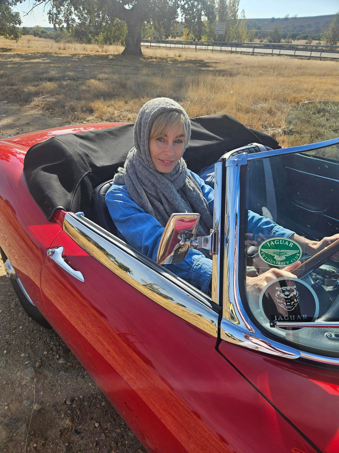 woman wearing an alpaca wrap sitting in a classic car