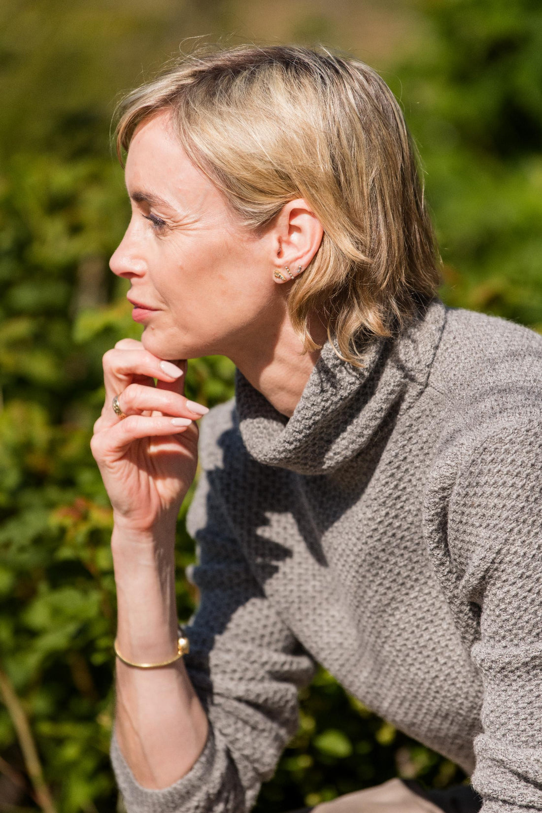  Close detail of a woman wearing a soft natural alpaca wool knit in Pebble, 