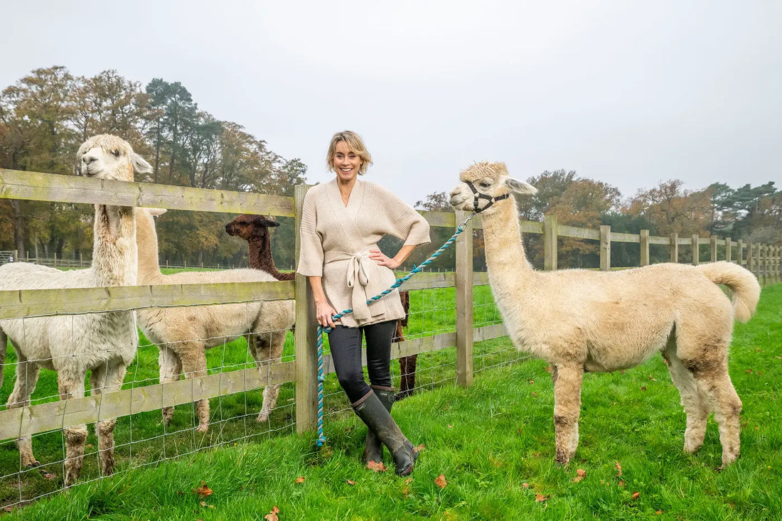 woman wearing an alpaca cardigan holding an alpaca
