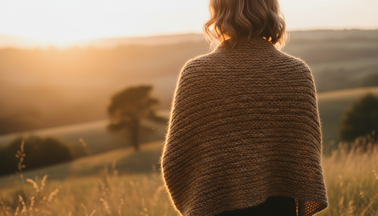 woman in knitted wrap looking out over the sunrise